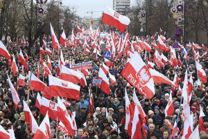 People carry Polish flags during a demonstration march in Warsaw