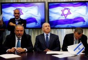 Avigdor Lieberman, head of far-right Yisrael Beitenu party, sits next to Israeli Prime Minister Benjamin Netanyahu as they sign a coalition deal to broaden the government's parliamentary majority, at the Knesset, the Israeli parliament in Jerusalem